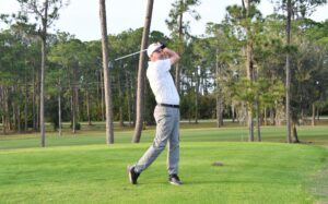 Golfer swinging at the golf course.